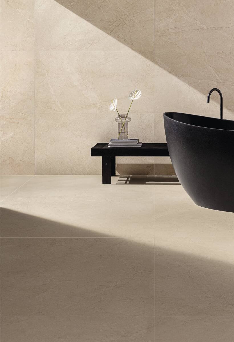 Banheiro em cores neutras com porcelanato bege e banheira de apoio na cor preta
